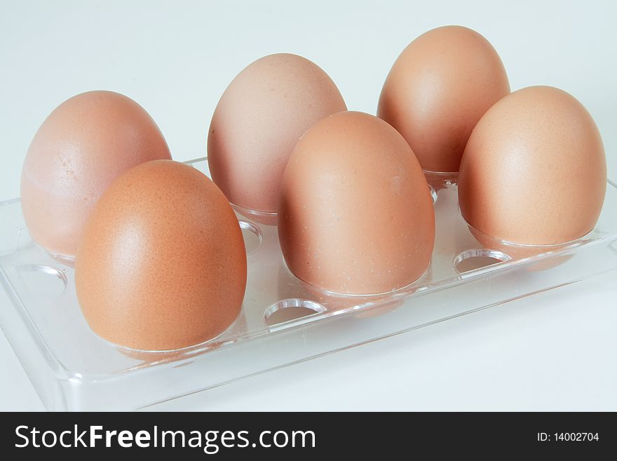 Six fresh poultry eggs in a fridge rack. Six fresh poultry eggs in a fridge rack.