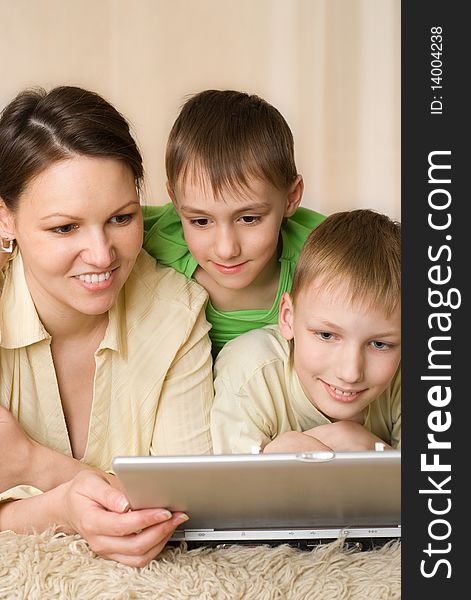 Happy mother with her children about looking at laptop
