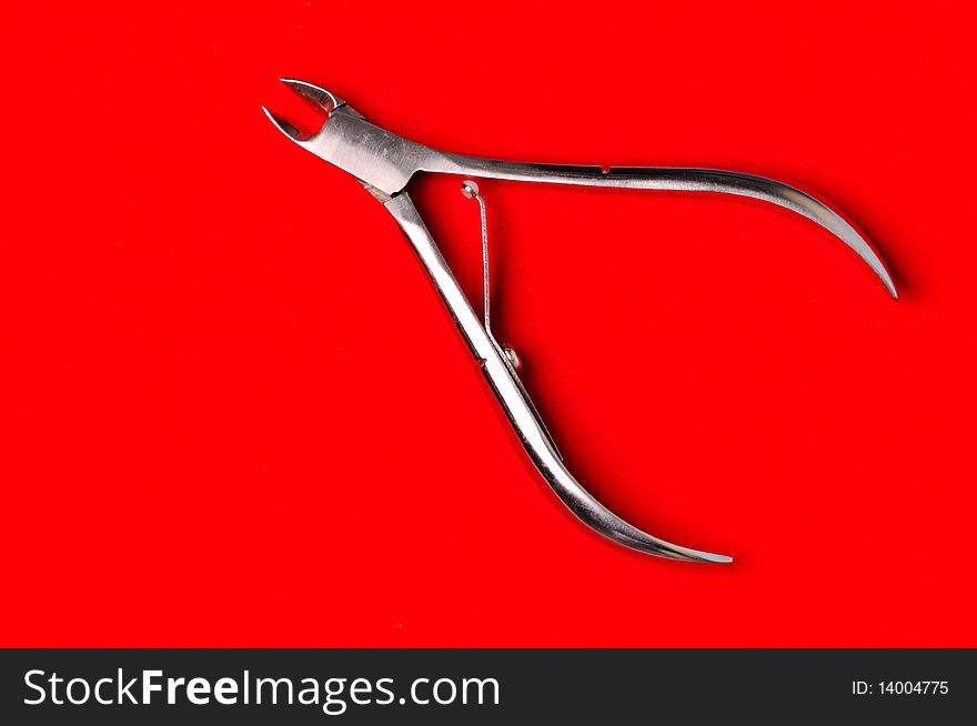 Pedicure pliers on the red background. Pedicure pliers on the red background.