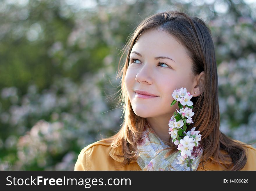 Young woman posing with a blooming branch in a spring park. Young woman posing with a blooming branch in a spring park