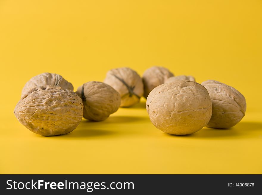 Handful of walnuts on a yellow background