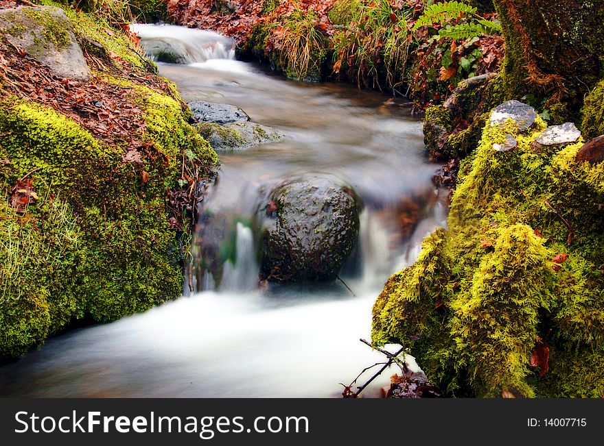 Long exposure of a small stream with a waterfall