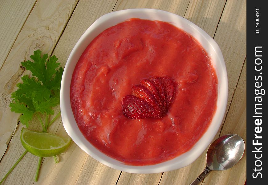 A bowl full of delicious strawberry cream and yoghurt, on rustic wooden table