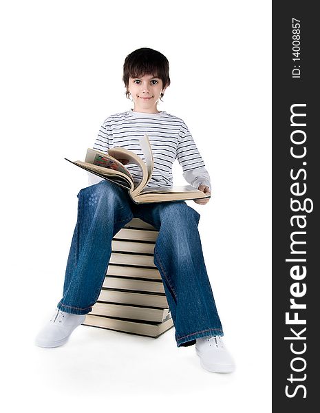 Cute little boy sit on a stack of big books on white background