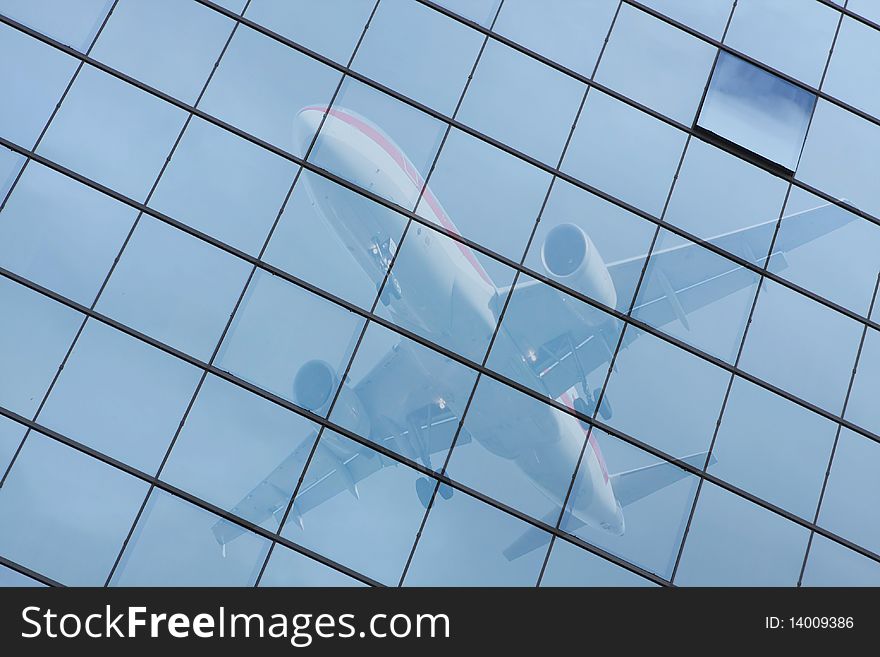 Building with a glass pattern with an airplane reflected