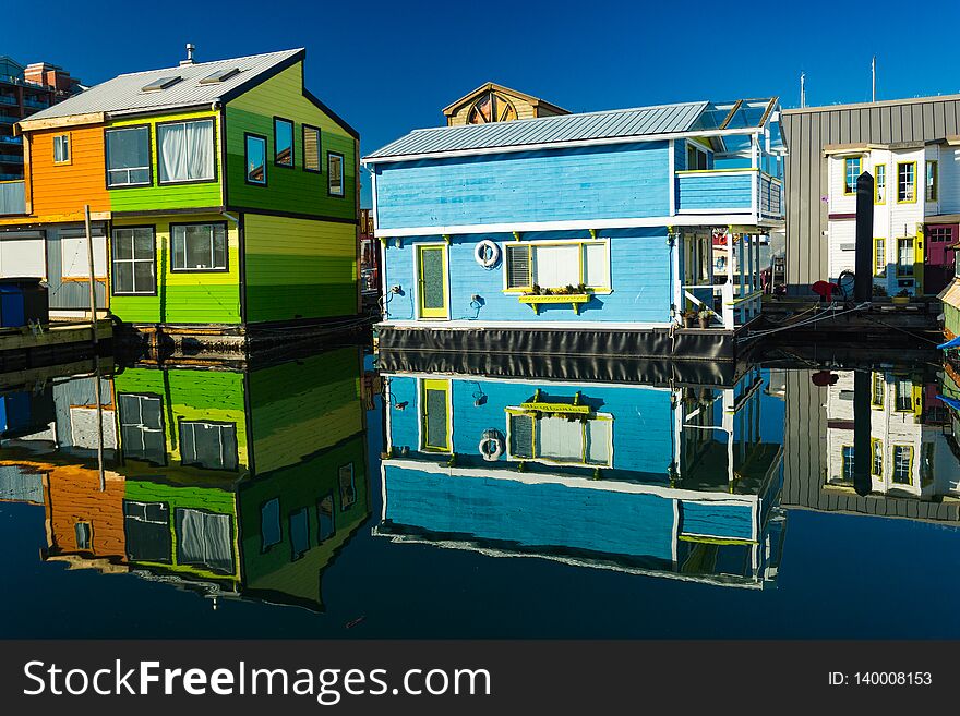 Colorful village of float homes on bright sunny day, blue sky.