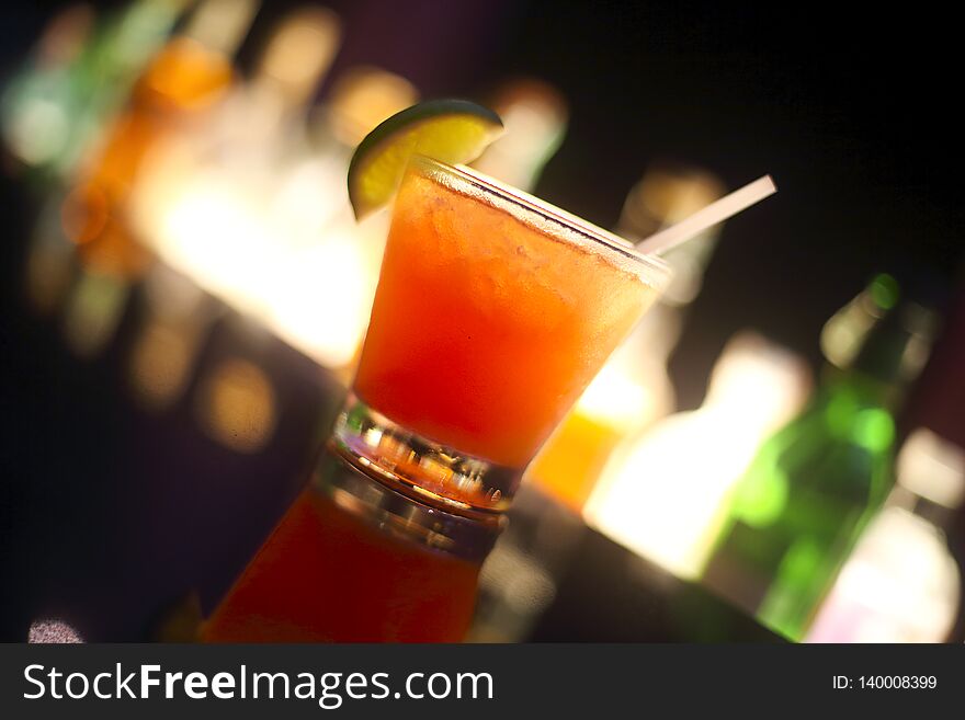 Tequila sunrise cocktail on night bar background