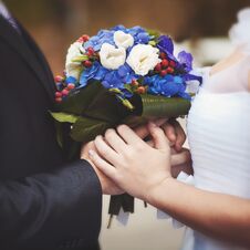 The Bride And Groom Are Holding A Bouquet Of Flowers. Royalty Free Stock Photography