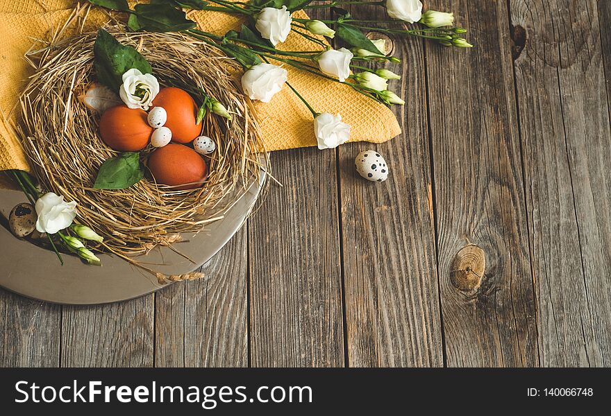 Happy Easter background. Easter eggs in a nest on a metal plate on a wooden background. Happy Easter concept