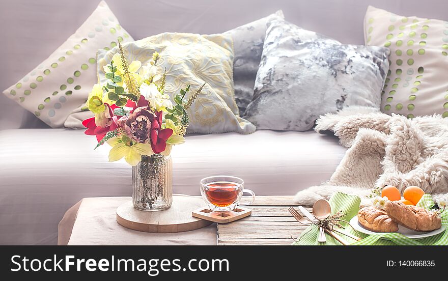 Homely cozy spring interior in the living room with a vase and flowers homemade breakfast, home comfort concept