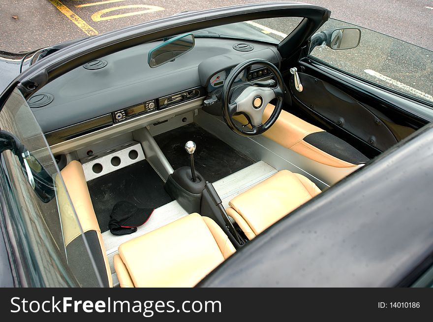 An image of the interior of a classic sports car with the hood down. An image of the interior of a classic sports car with the hood down.