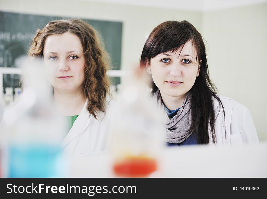 Young woman students group in bright chemistry  lab. Young woman students group in bright chemistry  lab
