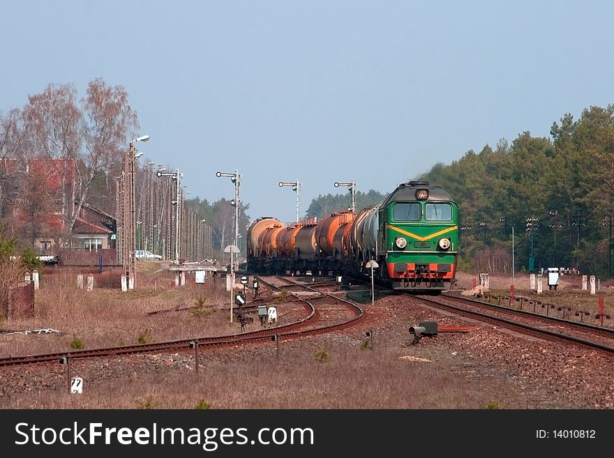 Freight train hauled by the diesel locomotive leaving the station in the middle of the woods. Freight train hauled by the diesel locomotive leaving the station in the middle of the woods