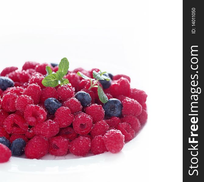 Wild raspberries and blueberries on the plate
