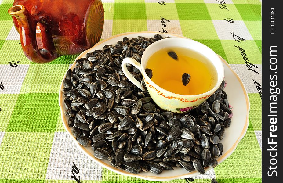 Image of sunflower seeds on a saucer with a cup of sunflower oil