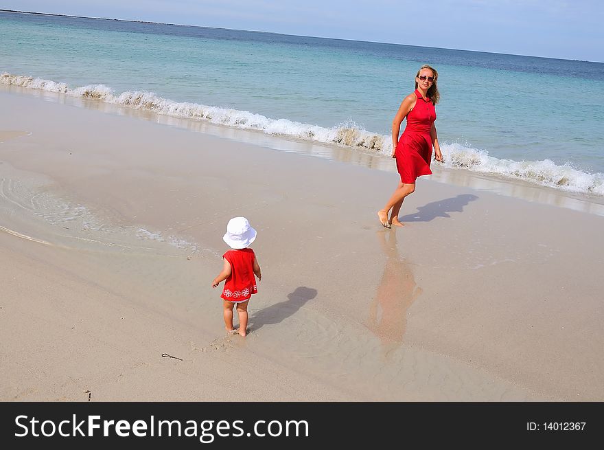 Mother and daughter walking along the ocean