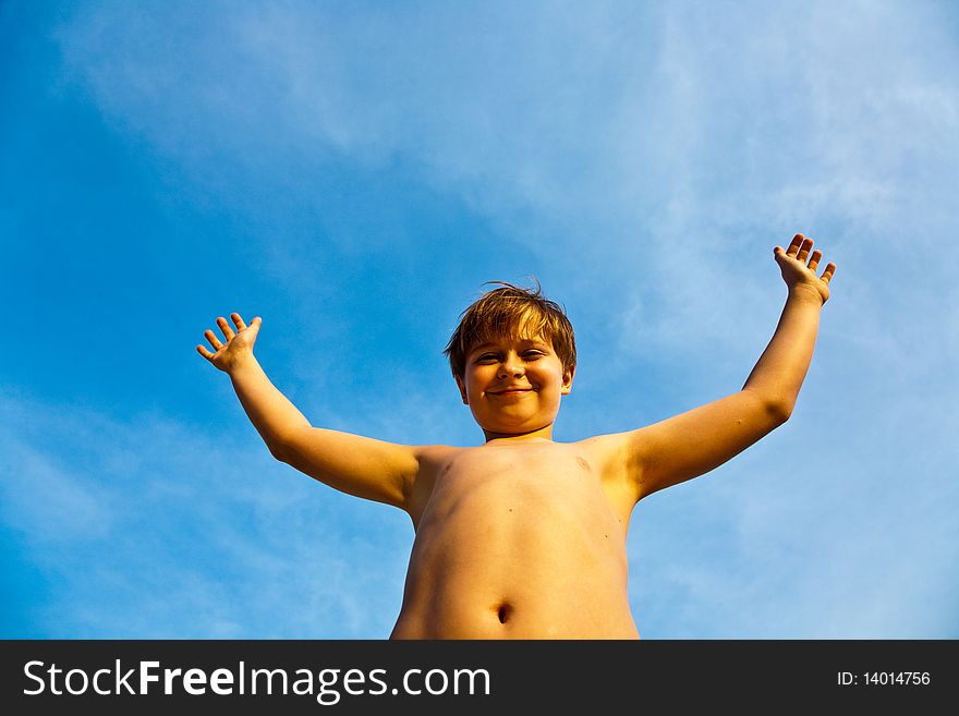 Young Boy Rises His Arms At The Beach