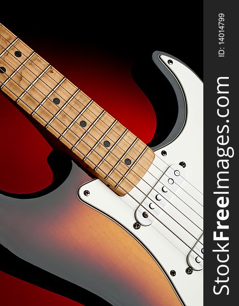 Vertical image of an electric guitar with a dirty worn maple neck on red glow. Vertical image of an electric guitar with a dirty worn maple neck on red glow