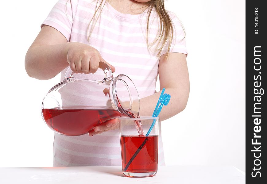Girl is pouring juice in a glass
