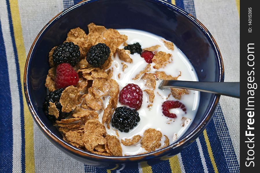 Bowl of cereal with milk and berries on a striped