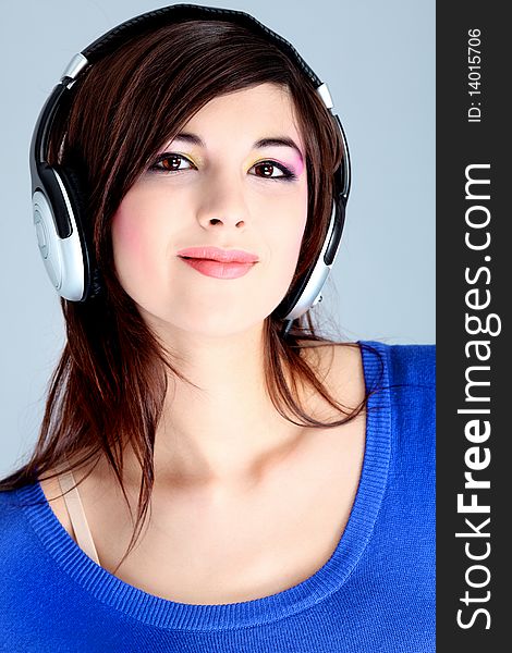 Shot of a pretty young woman in headphones listening to music with pleasure. Shot in a studio. Shot of a pretty young woman in headphones listening to music with pleasure. Shot in a studio.