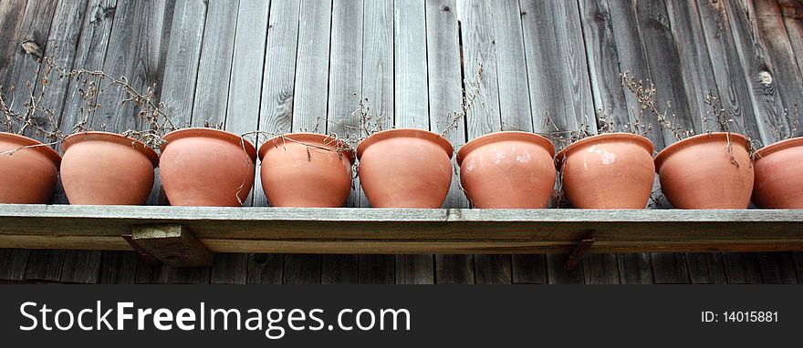 An artistic image of pottery on a wooden shelf.