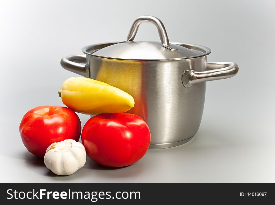Pepper, garlic, tomato and pan on grey background. Pepper, garlic, tomato and pan on grey background