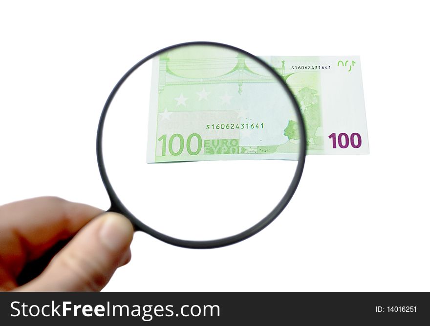 100 euro banknote being inspected under the magnifying glass in the hand. 100 euro banknote being inspected under the magnifying glass in the hand