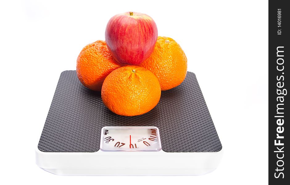 Three oranges and apple on the scales, isolated on white. Three oranges and apple on the scales, isolated on white