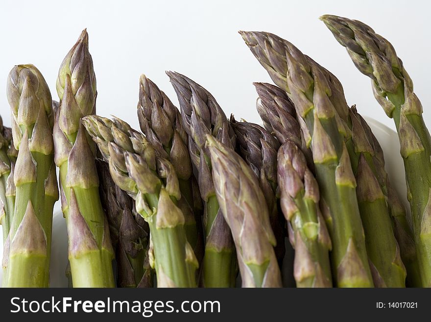 The tips of Asparagus spears against a white background. The tips of Asparagus spears against a white background.