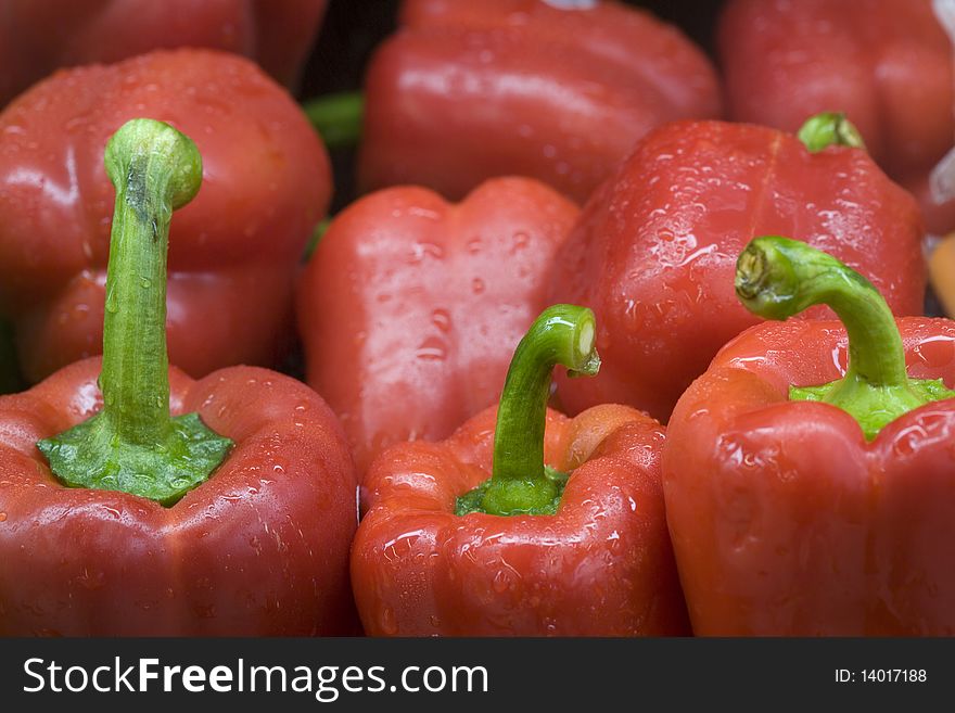 Bright red bell peppers with green stems. Bright red bell peppers with green stems.