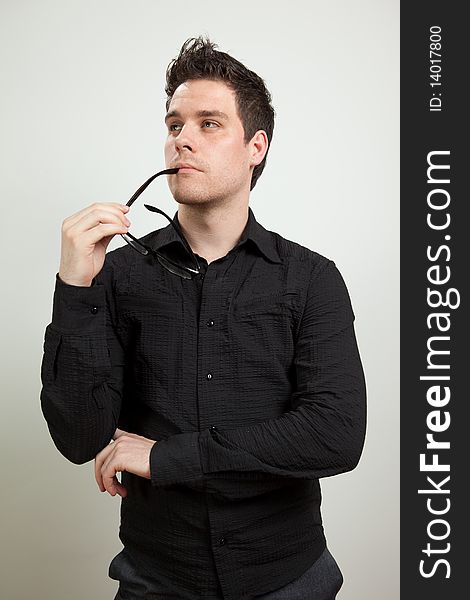 Young man standing and holding glasses. Young man standing and holding glasses