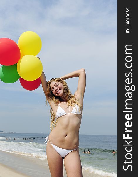 Woman holding colorful balloons on the beach