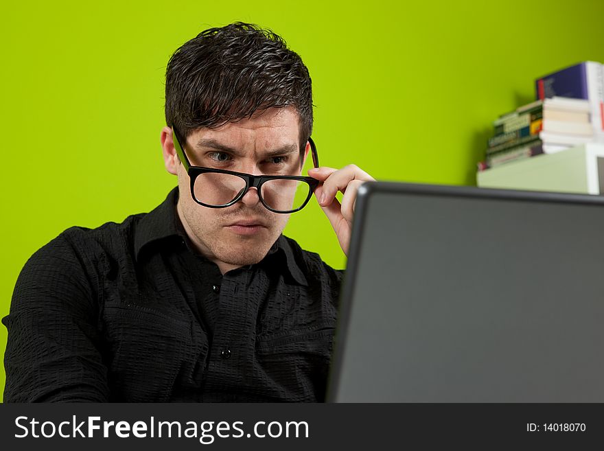 Young man squinting at the laptop. Young man squinting at the laptop