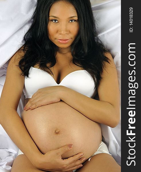 Beautiful pregnant woman holds her tummy on the bed. Beautiful pregnant woman holds her tummy on the bed