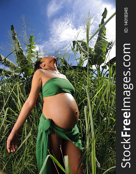 Woman is pregnant in the jungle and looks to the sky. Woman is pregnant in the jungle and looks to the sky