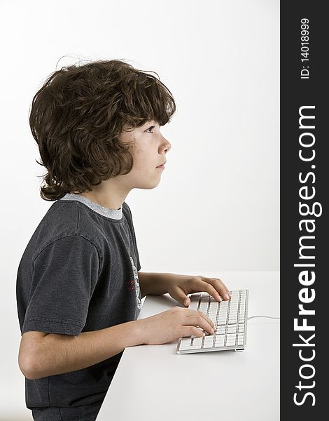 Young boy working on a computer isolated on white. Young boy working on a computer isolated on white