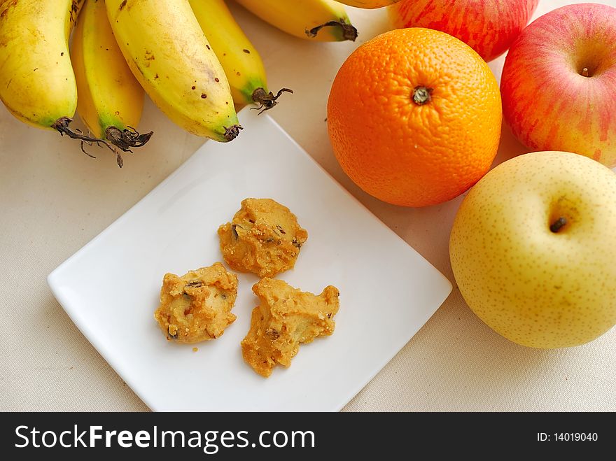 Contrast of fruits and unhealthy snack to signify concepts such as healthy lifestyle, diet and nutrition, and food and beverage.