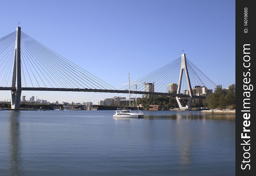 Anzac Bridge & Sydney CBD with a yacht on the harbour in the foreground