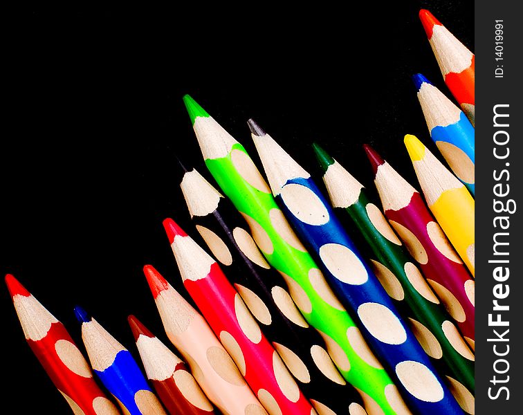 Colored crayons over black backround, indoor shoot