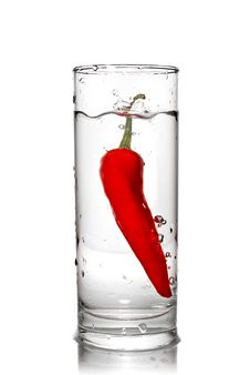 Red Pepper Dropped Into Water Glass Royalty Free Stock Image
