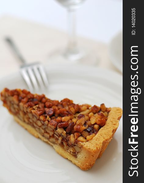 A single slice of hazel nut tart on white plate. For concepts such as food and beverage, diet and nutrition, and healthy eating.