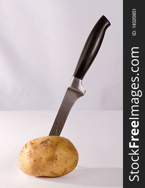 Knife in potato on the table