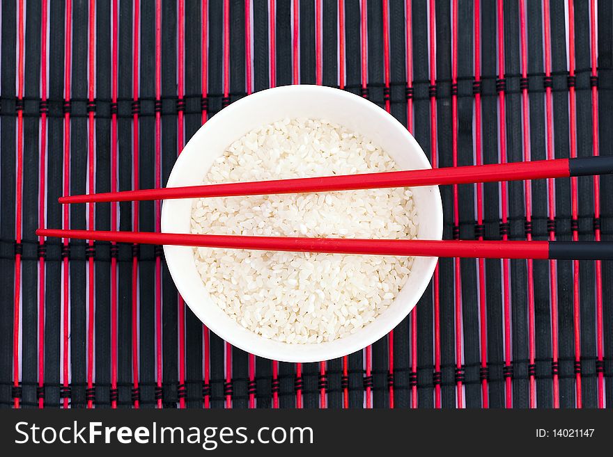 Light rice in a bowl in chopsticks. Light rice in a bowl in chopsticks