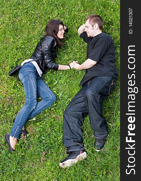 Man and woman lie on a green grass. Man and woman lie on a green grass.