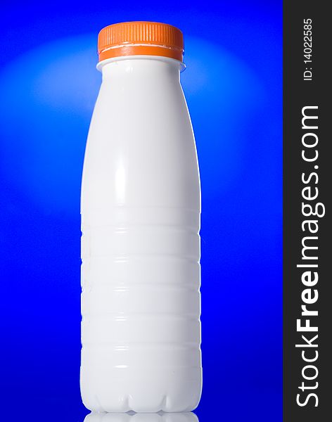 White milk bottle isolated on blue background