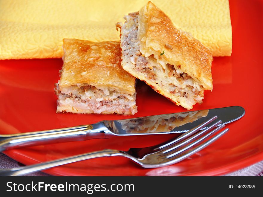 Appetizing homemade baked meat pie on red plate. Appetizing homemade baked meat pie on red plate