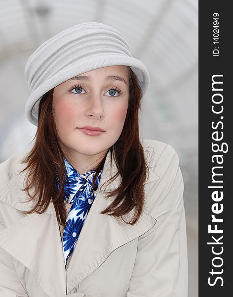 The young beautiful girl the brown-haired woman in a light hat with a blue scarf looks directly in the chamber. The young beautiful girl the brown-haired woman in a light hat with a blue scarf looks directly in the chamber