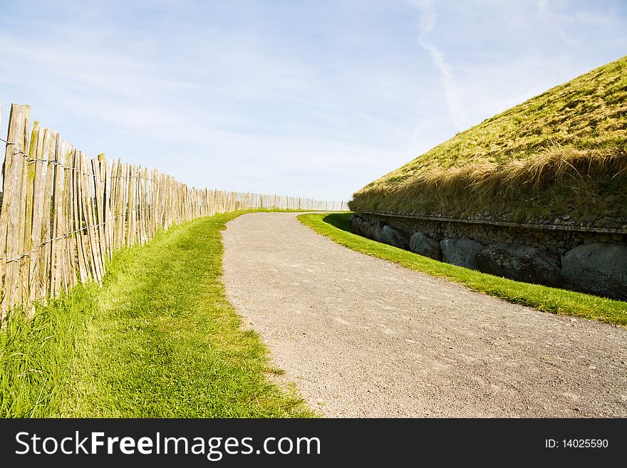 UNESCO World Heritage - Newgrange, megalithic passage tomb in Ireland. View over the old road and fence at the back of the monument. UNESCO World Heritage - Newgrange, megalithic passage tomb in Ireland. View over the old road and fence at the back of the monument.