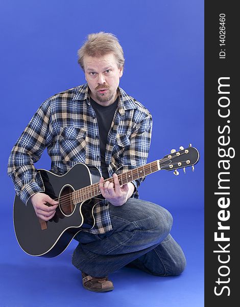 Studio portrait of a man posing with guitar. Studio portrait of a man posing with guitar.